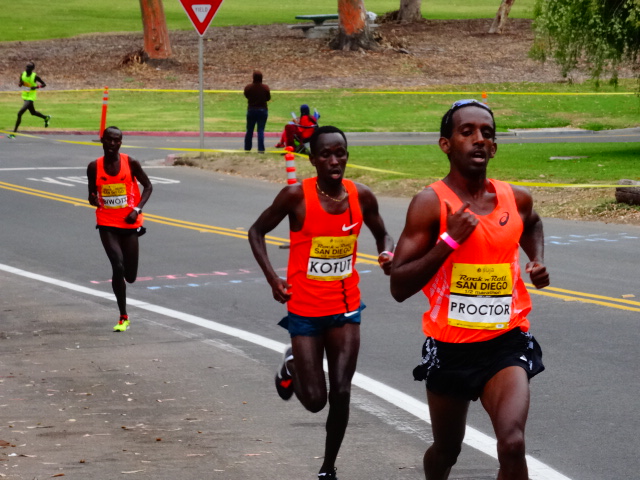 Mammoth TC's Gabe Proctor (eventual 9th - 61:39) presses Kenya's Cybrian Kotut (7th - 1:01:38) with USA's Shadrack Biwott coming strong ( 6th - 1:01:24)